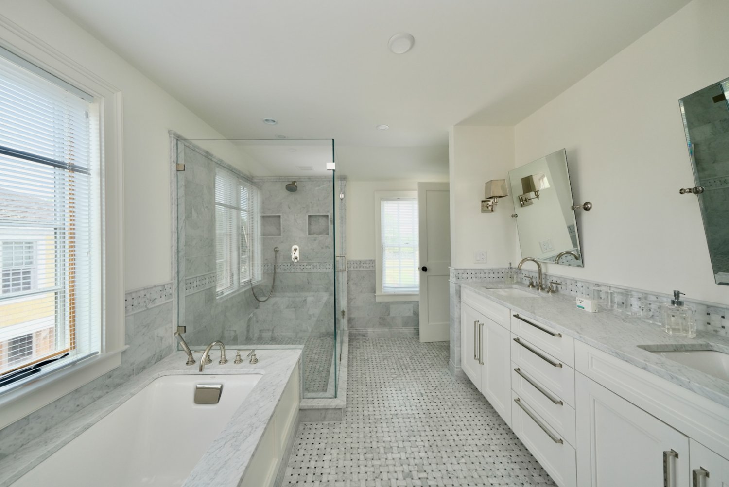 This bathroom has a separate tub and shower and stone-topped dual vanity.