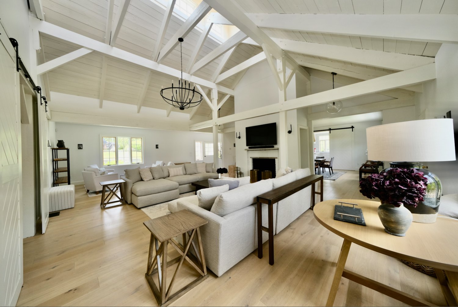 The living room has wood floors, an exposed-beam ceiling and a double-sided fireplace.