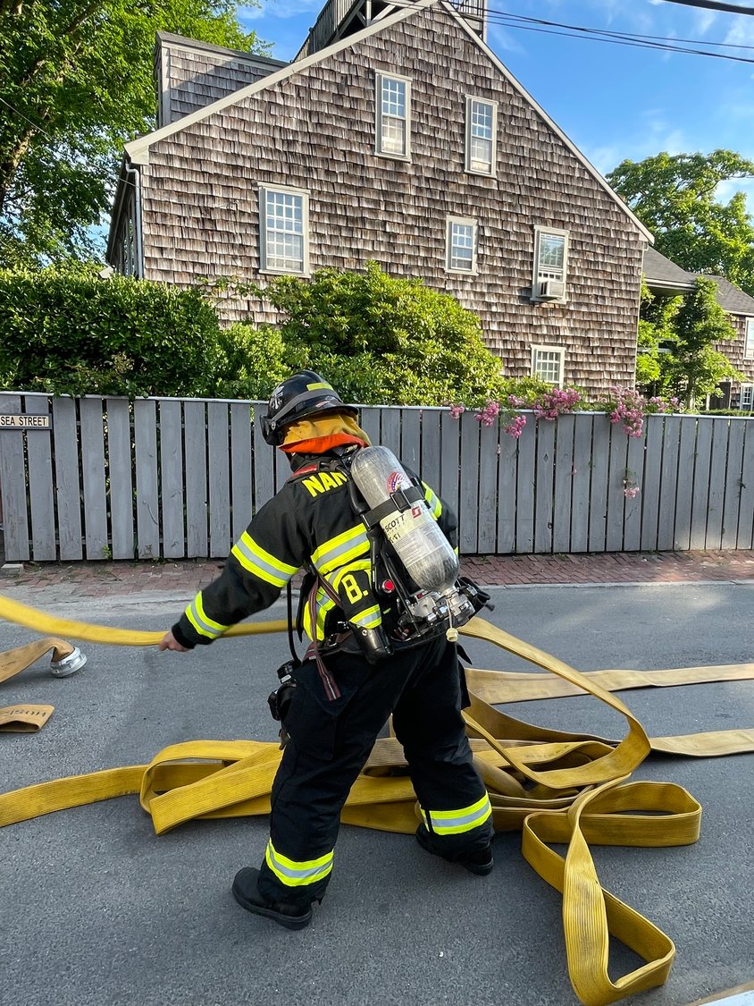 A firefighter preps a hose.