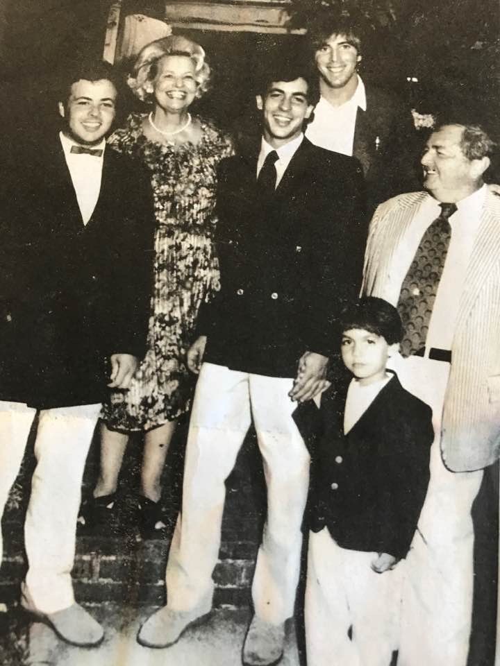 A photo of the Devine family in the early 1980s. From left are Shaun Devine, Jo Devine, Tom Devine Jr., holding his son Ethan’s hand, Tom Devine Sr., and in the background family friend and Boston Globe photographer Stan Grossfeld.