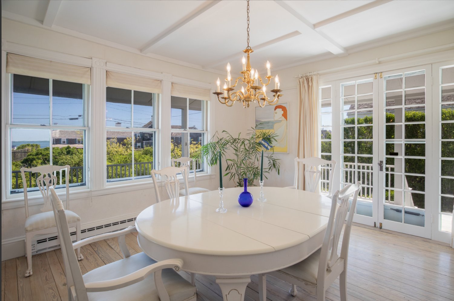 The bright and airy dining room of this Hulbert Avenue home has wood floors, water views and French doors that open to the covered wrap-around porch.