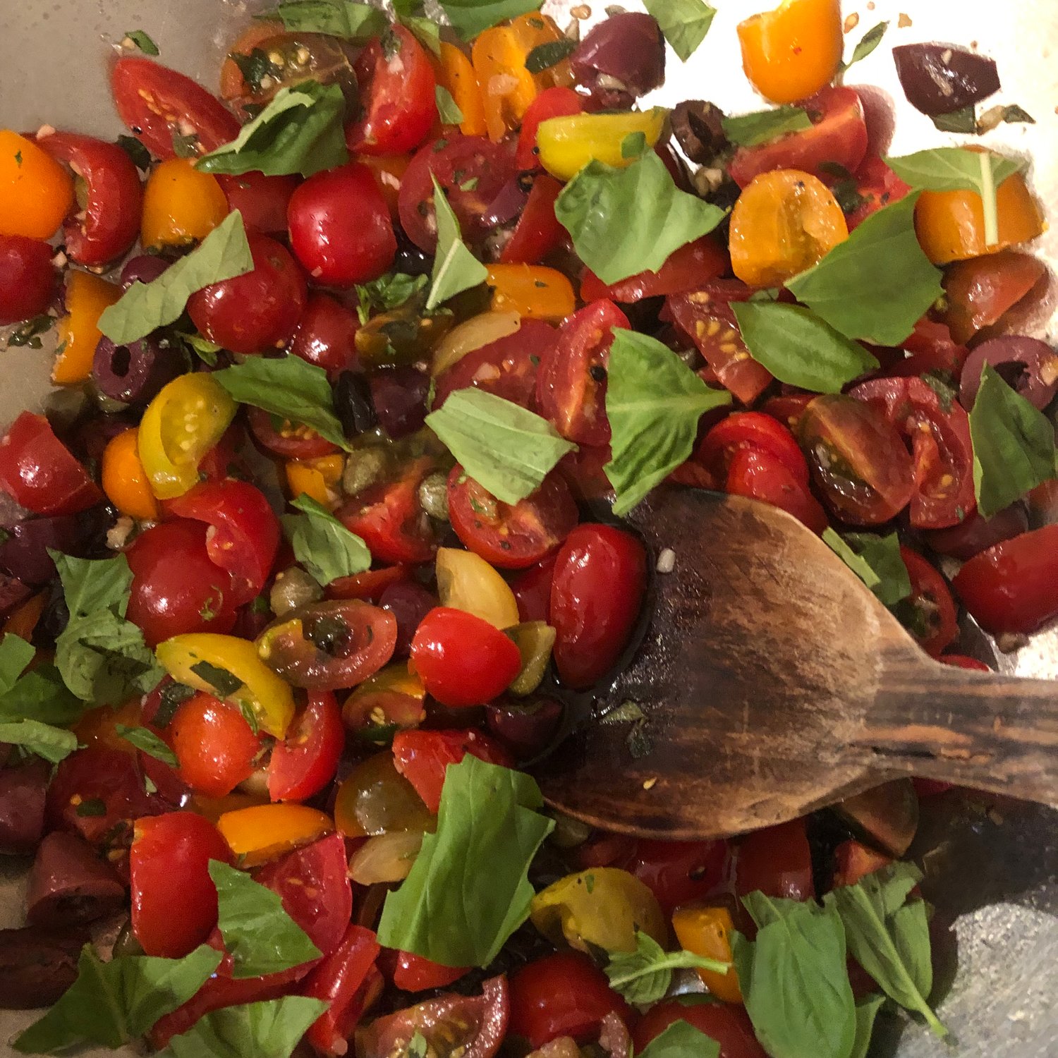 Tomatoes, olives, capers, basil and garlic marinate in olive oil before being mixed with fusilli and stracchino cheese.