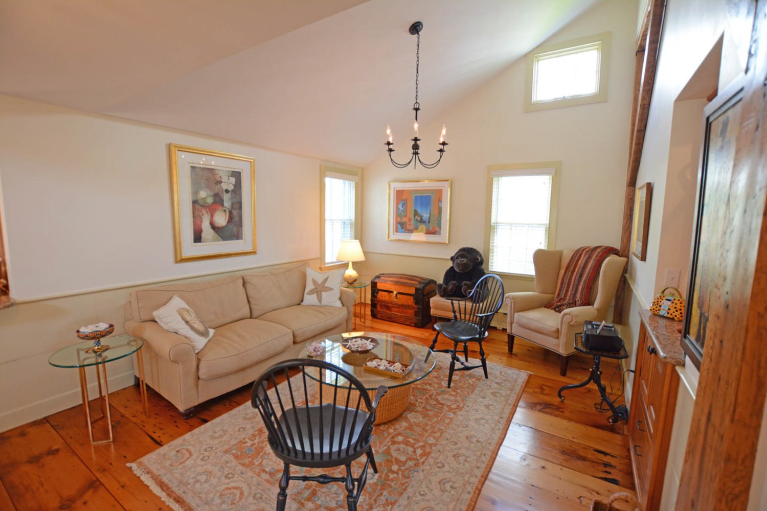 The sitting room has wide pine floors, beadboard wainscoting and a vaulted ceiling.