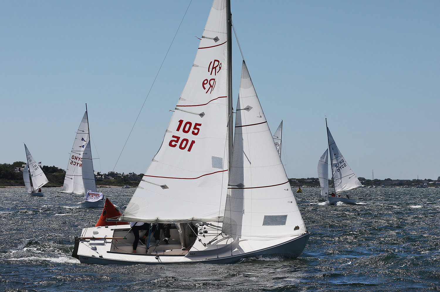 Boats race during the Women's Regatta in the harbor on Thursday.