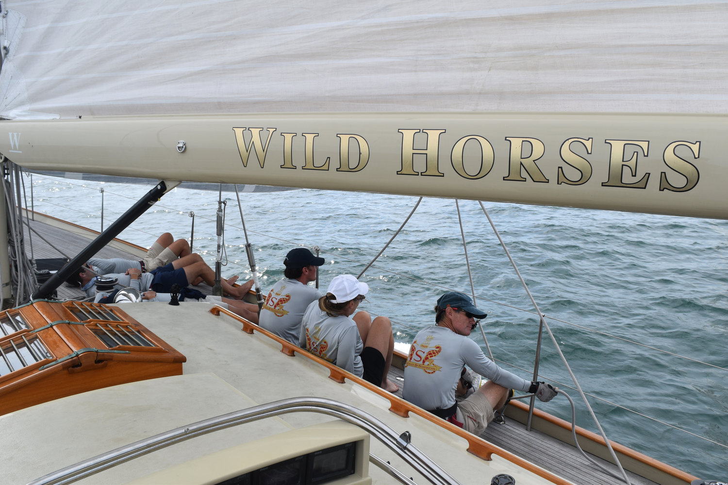 The crew of Wild Horses sitting along the port side of the boat.