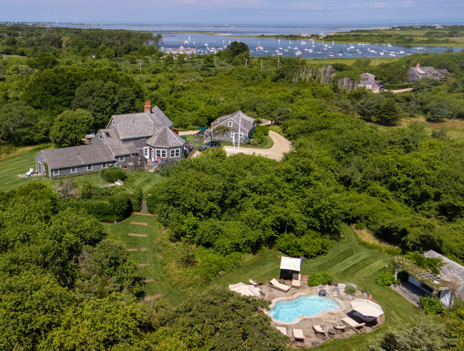 This rare hilltop family compound, located in the highly-desirable Wauwinet area, has seven bedrooms, seven bathrooms and views of Nantucket Sound and beyond to Coatue from the main home and guest cottage.