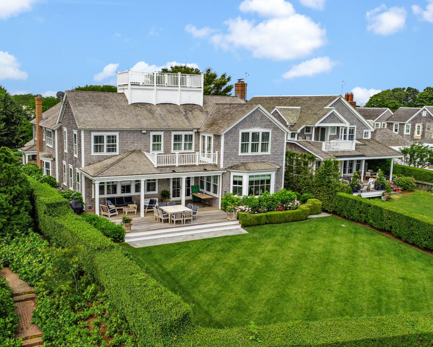 Sitting high in the Cliff Road neighborhood, just off prestigious Lincoln Circle, this seven-bedroom, six-and-two-half-bathroom home has picturesque views of Nantucket Harbor, Nantucket Sound and the far reaches of historic downtown.