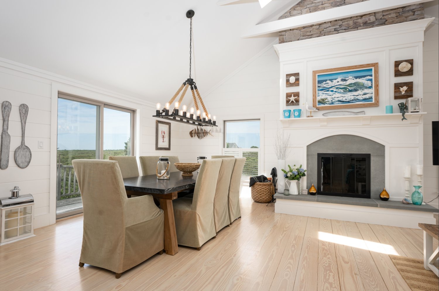 The open-concept second-floor combines the living and dining areas beneath cathedral ceilings, and has access to the deck with distant water views.