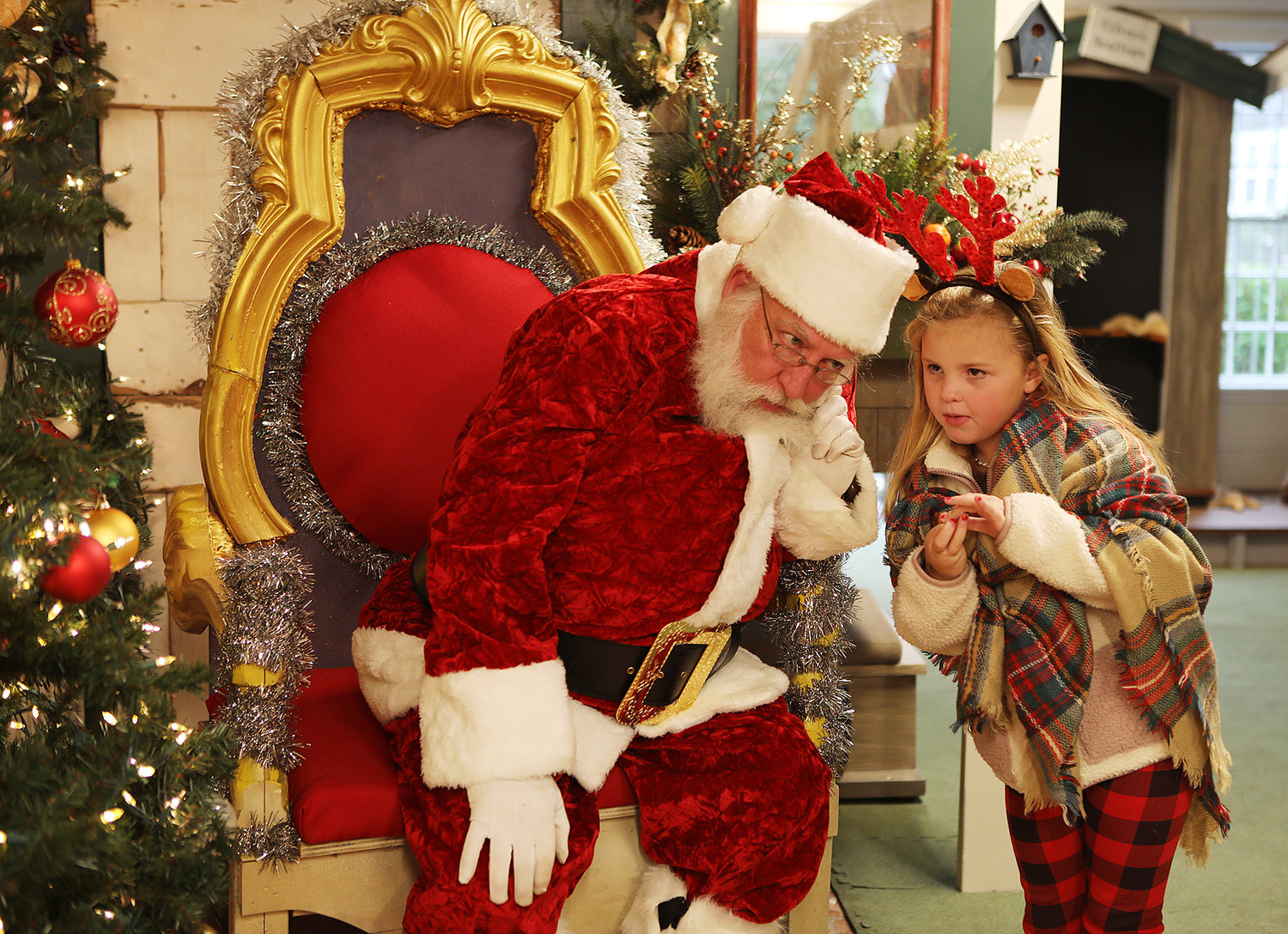 DECEMBER 3, 2022 -- Santa listens closely to the wishes of a young girl in the Discovery Room of the Whaling Museum during Christmas Stroll on Main Street. Photo by Ray K. Saunders
