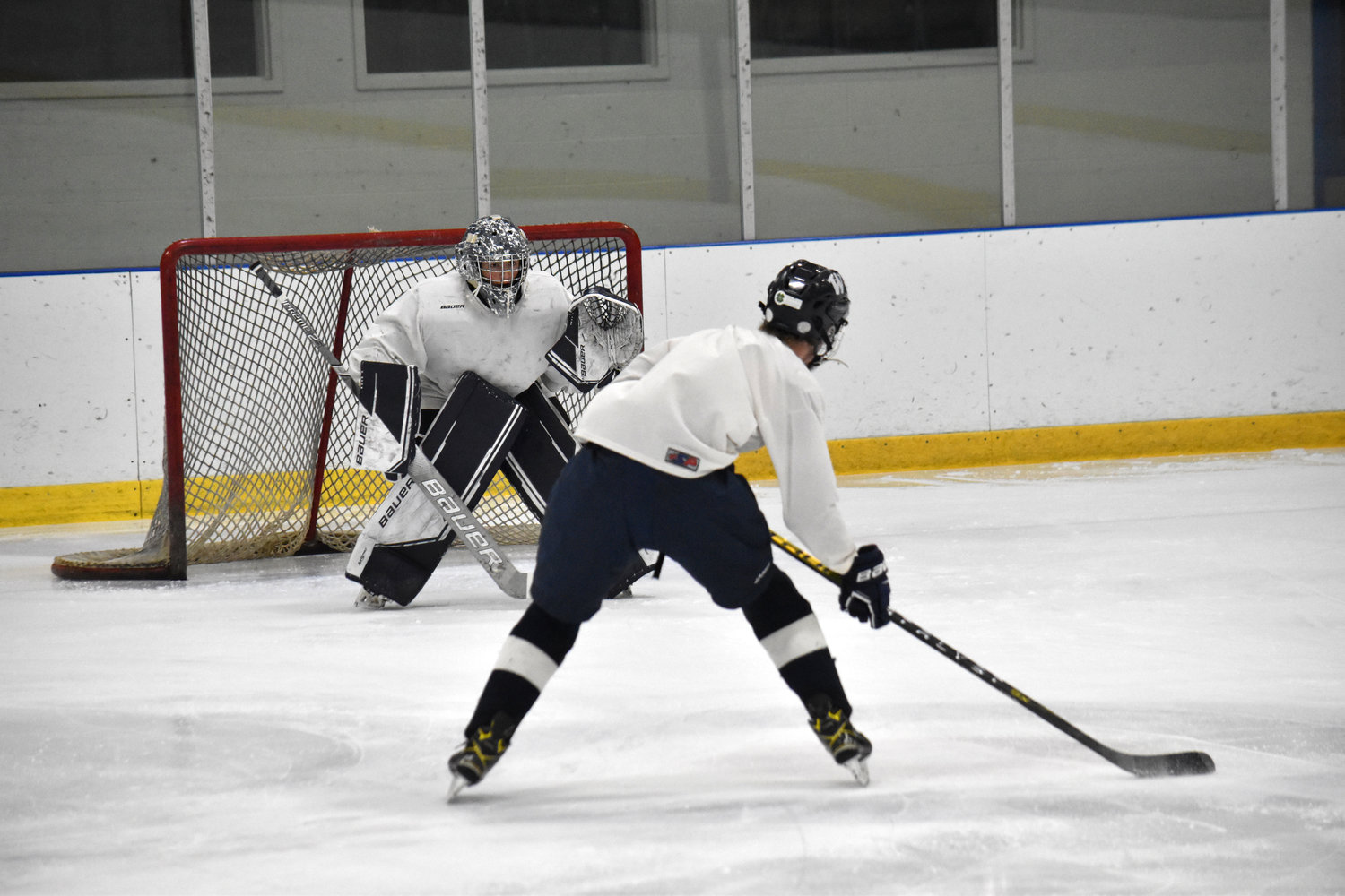 Goalie Griffin Starr prepares to face a shot during practice last week. The junior will be back in net for the boys hockey team this year.
