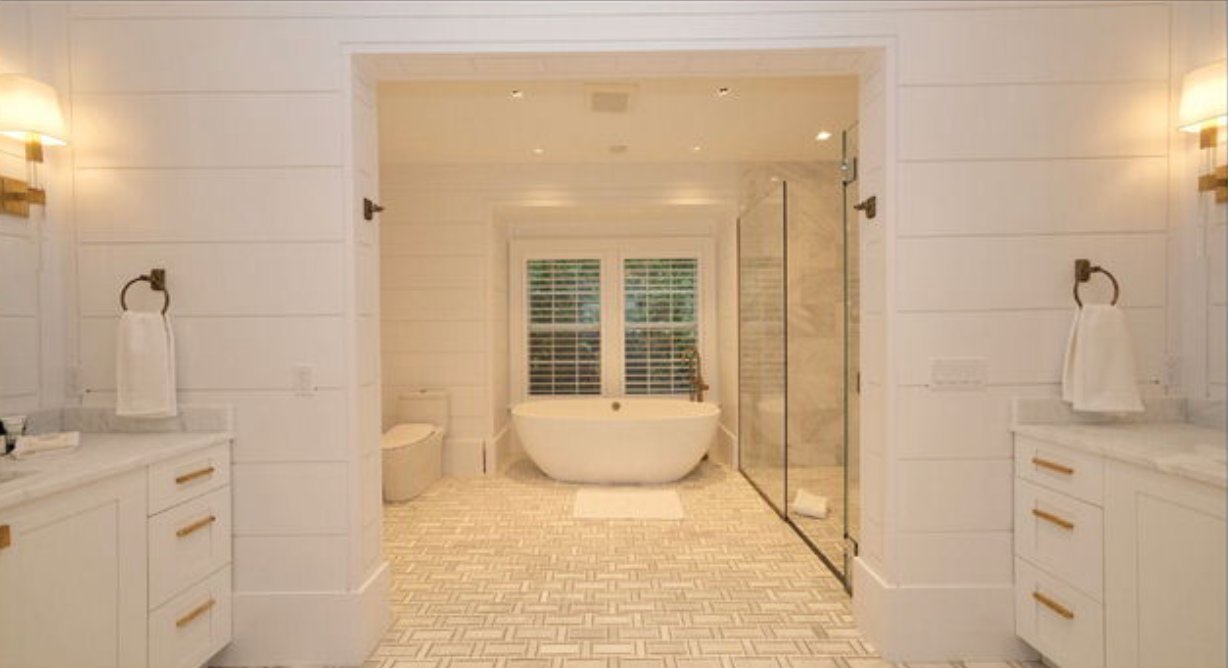 This spacious en-suite bathroom has dual vanities and a soaking tub.