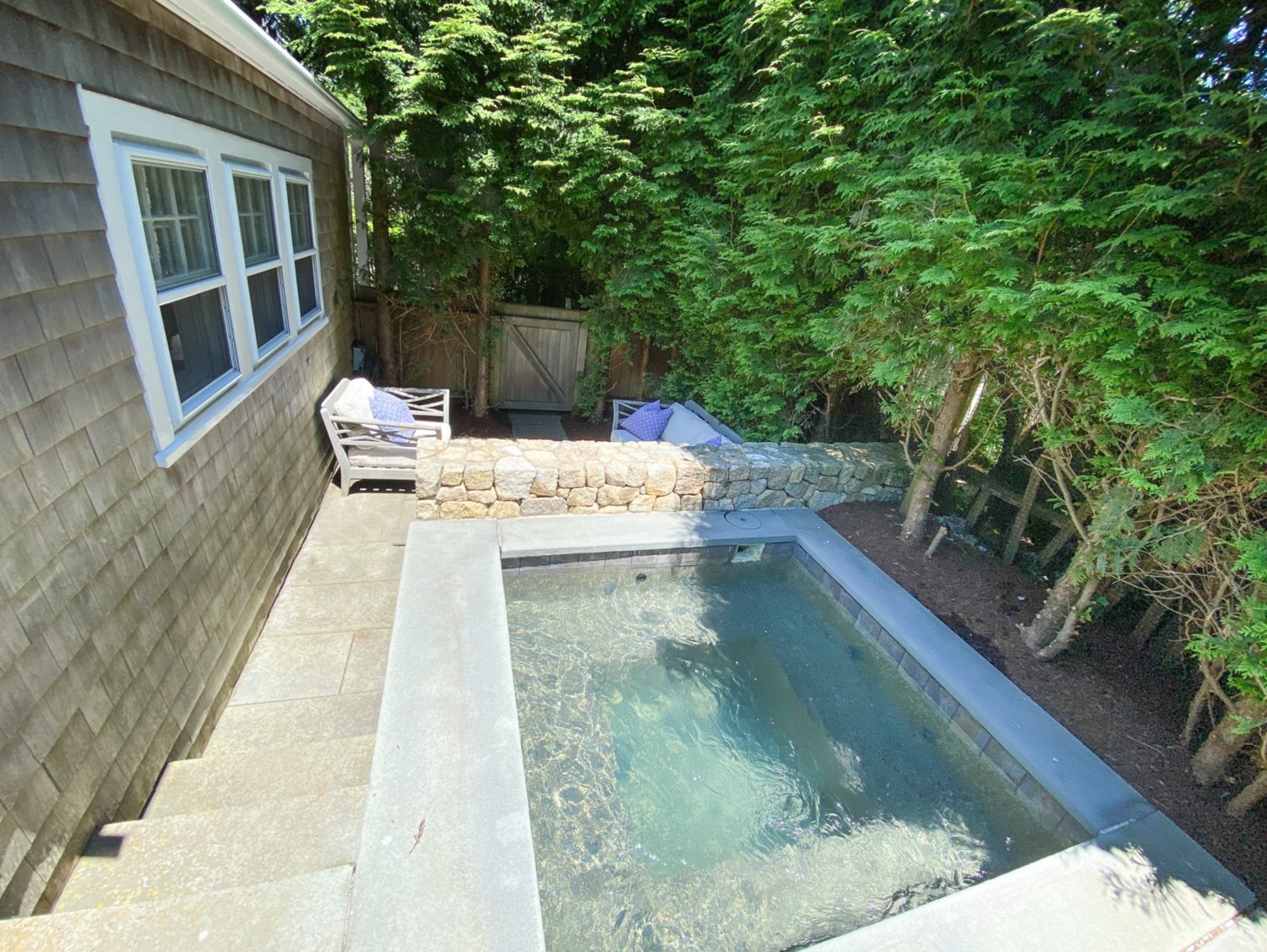Also outdoors is an in-ground hot tub with a stone surround.