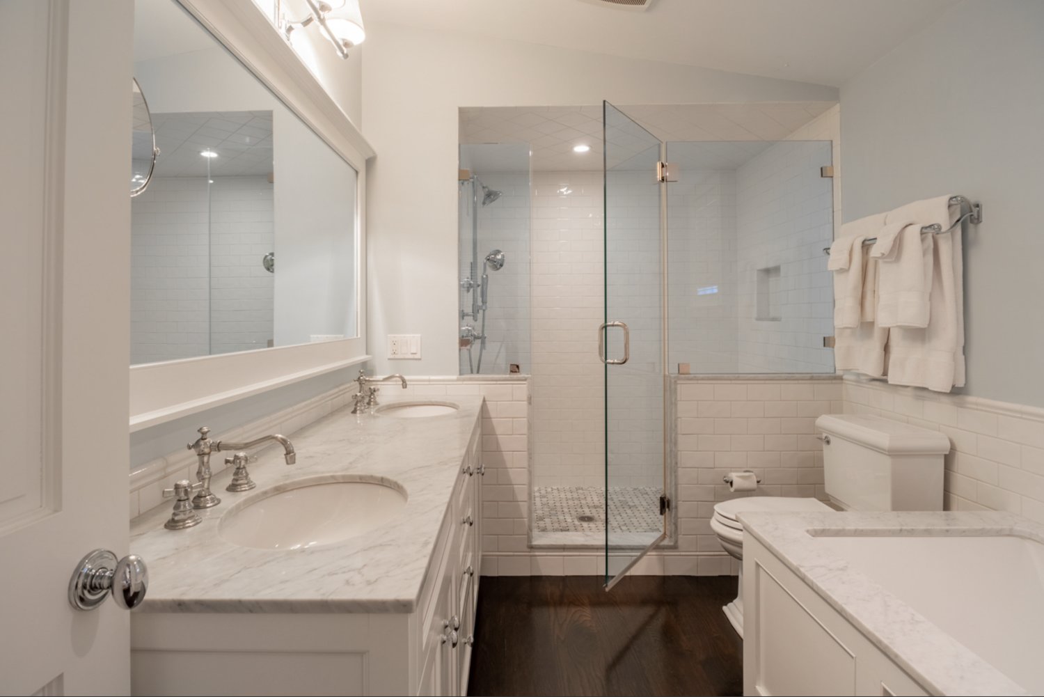 The en-suite master bath has his-and-her sinks and a glass and tile shower.
