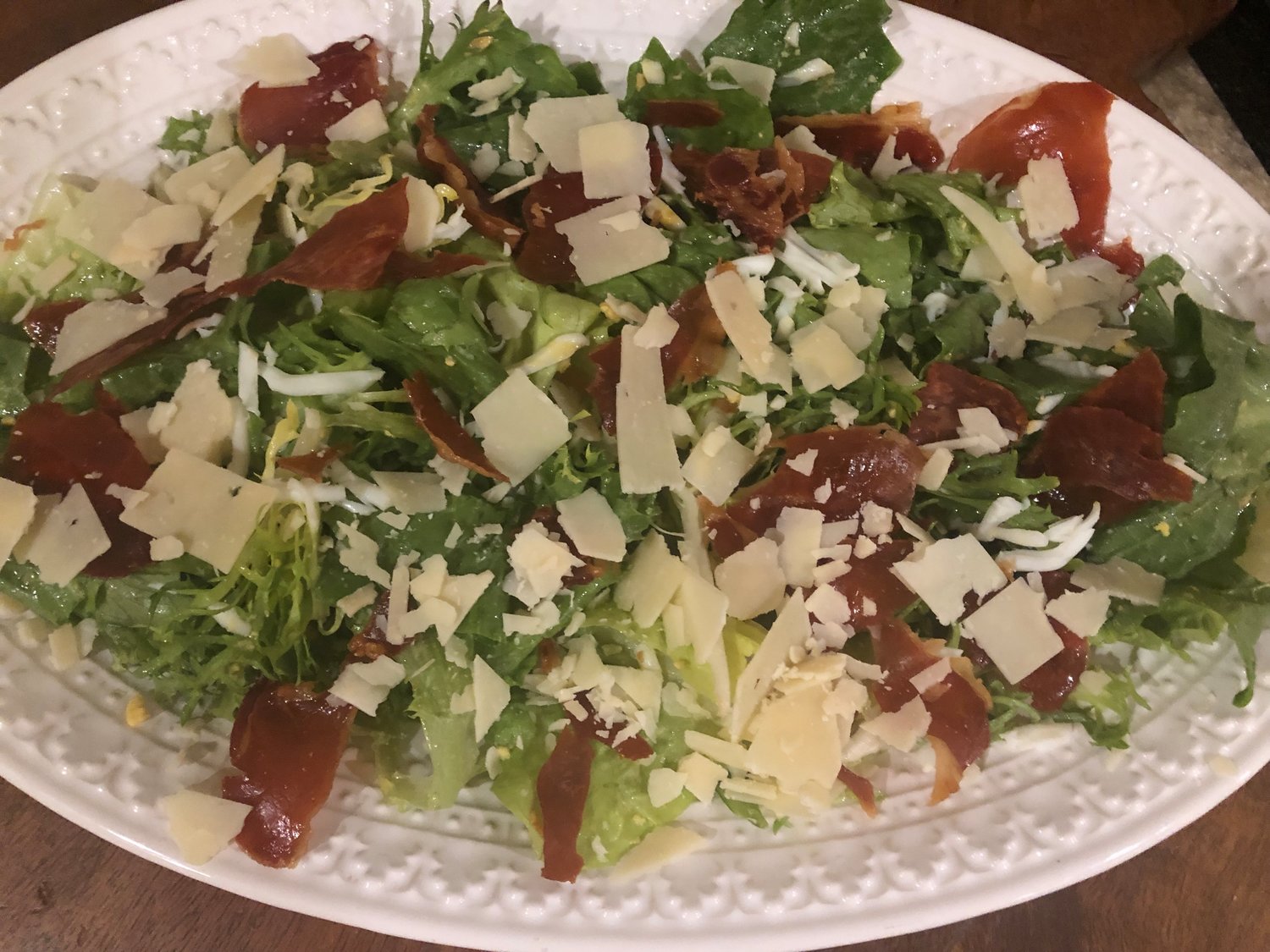 The star of this dish is the thinly-sliced prosciutto, crisped up in the oven and tossed with escarole in a lemon-anchovy vinaigrette and garnished with shards of Parmigiano-Reggiano.
