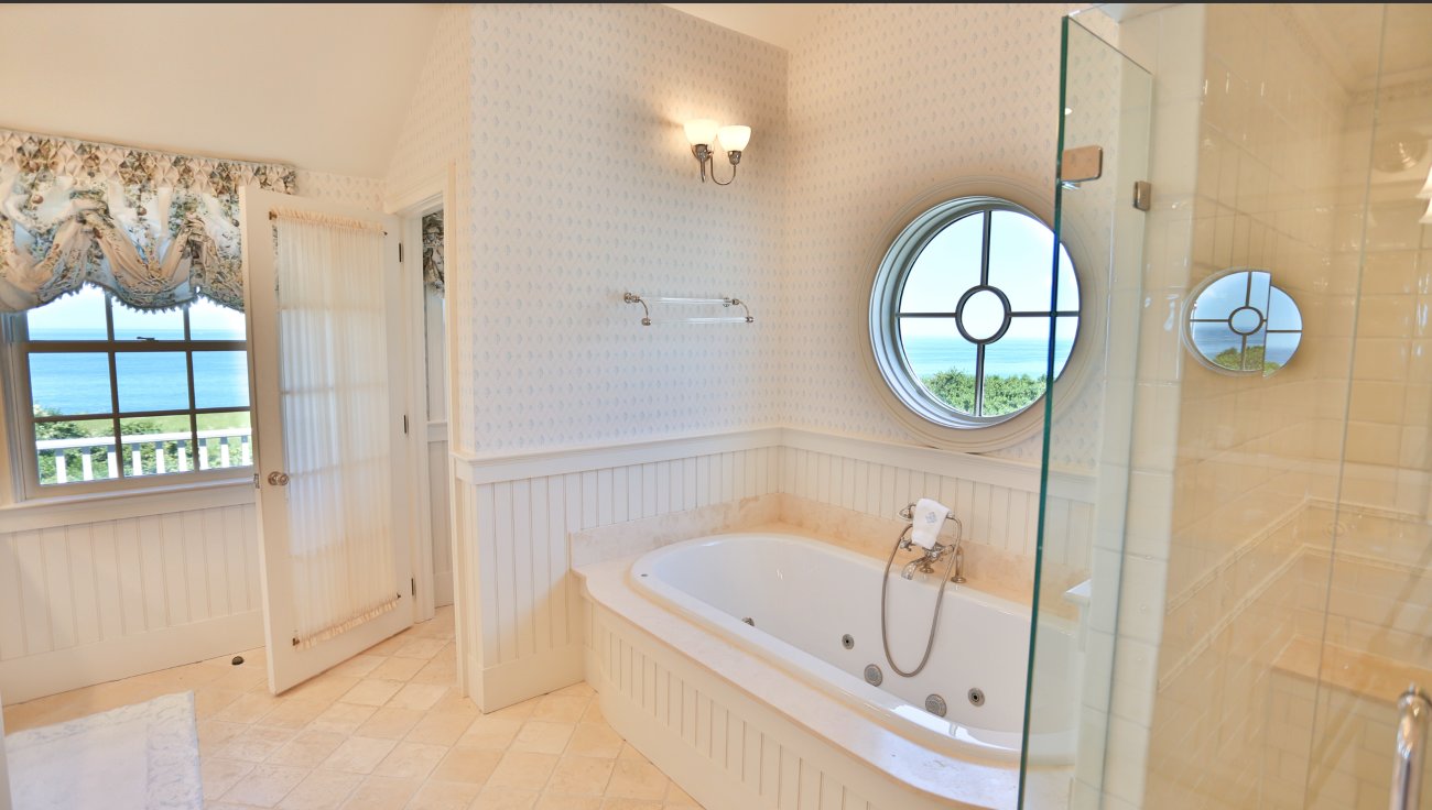 This bathroom has a jetted tub and separate shower, tiled floor and water views.