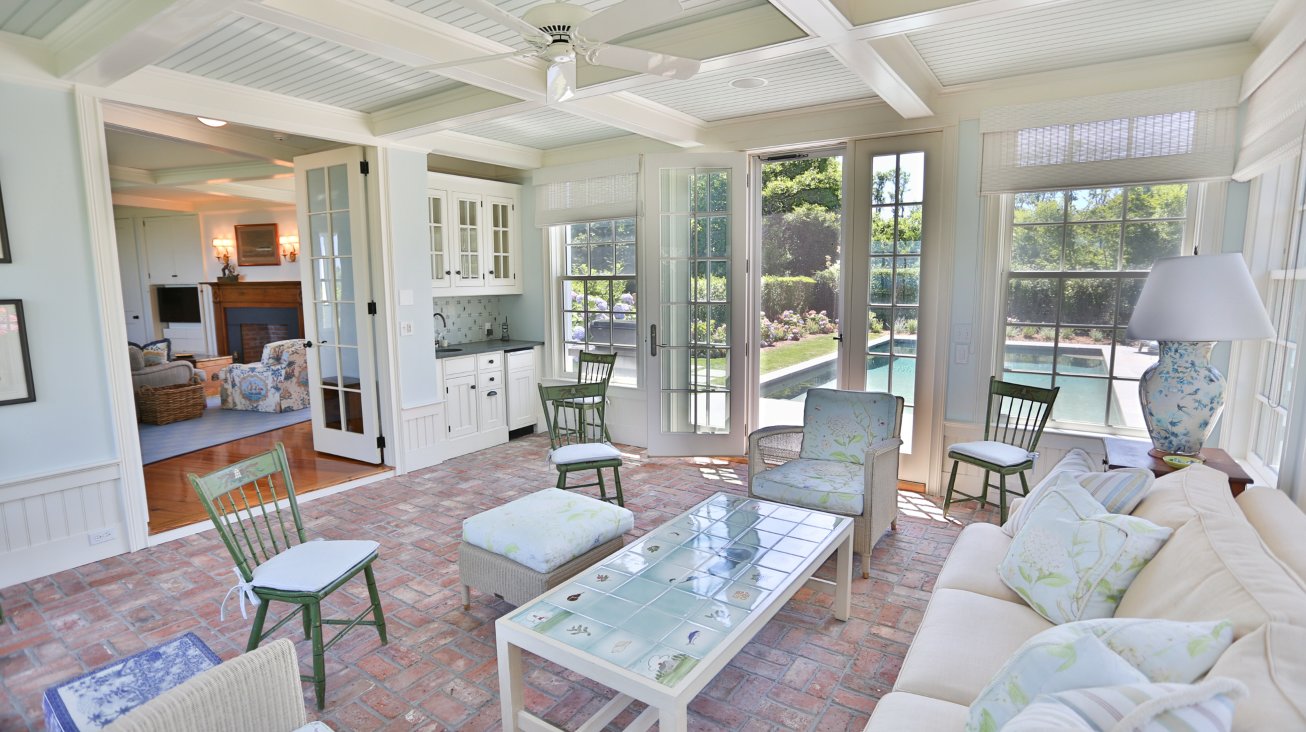 The brick-floored sunroom, located just off the family room, has a wet bar and access to the pool.
