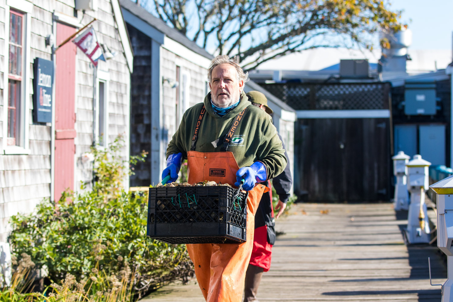 A Nantucket scalloper carries his catch on the dock at Straight Wharf last November.