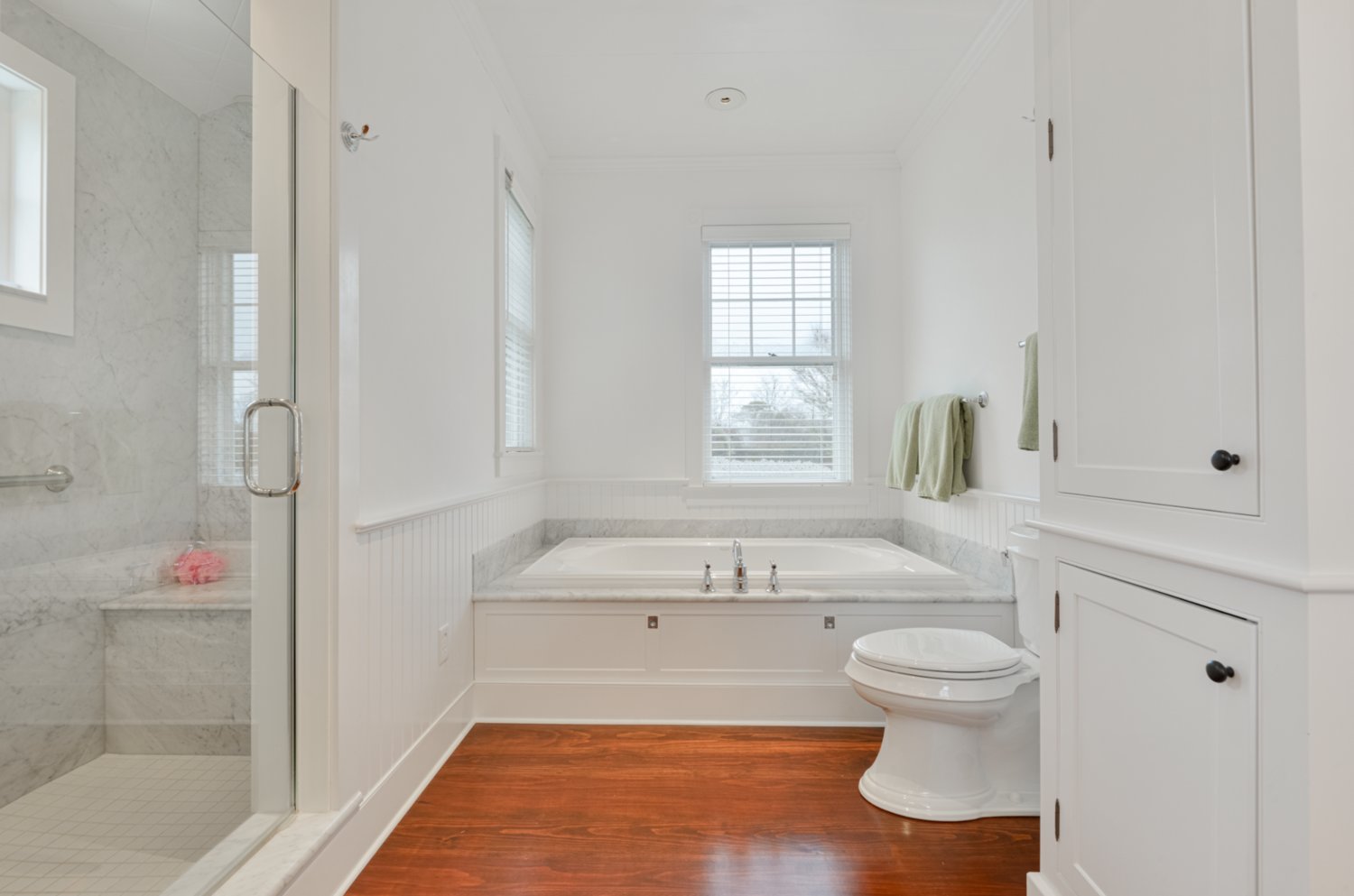 This bathroom has a soaking tub and separate glass-enclosed shower.