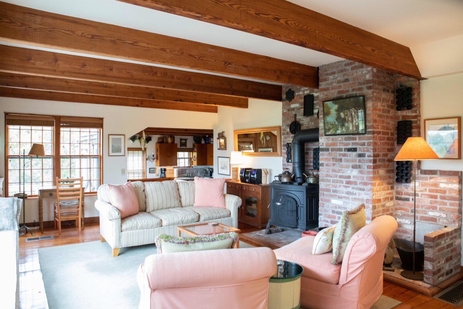 The open floor plan on the ground floor of the main house has water views and is accented by a wood stove.