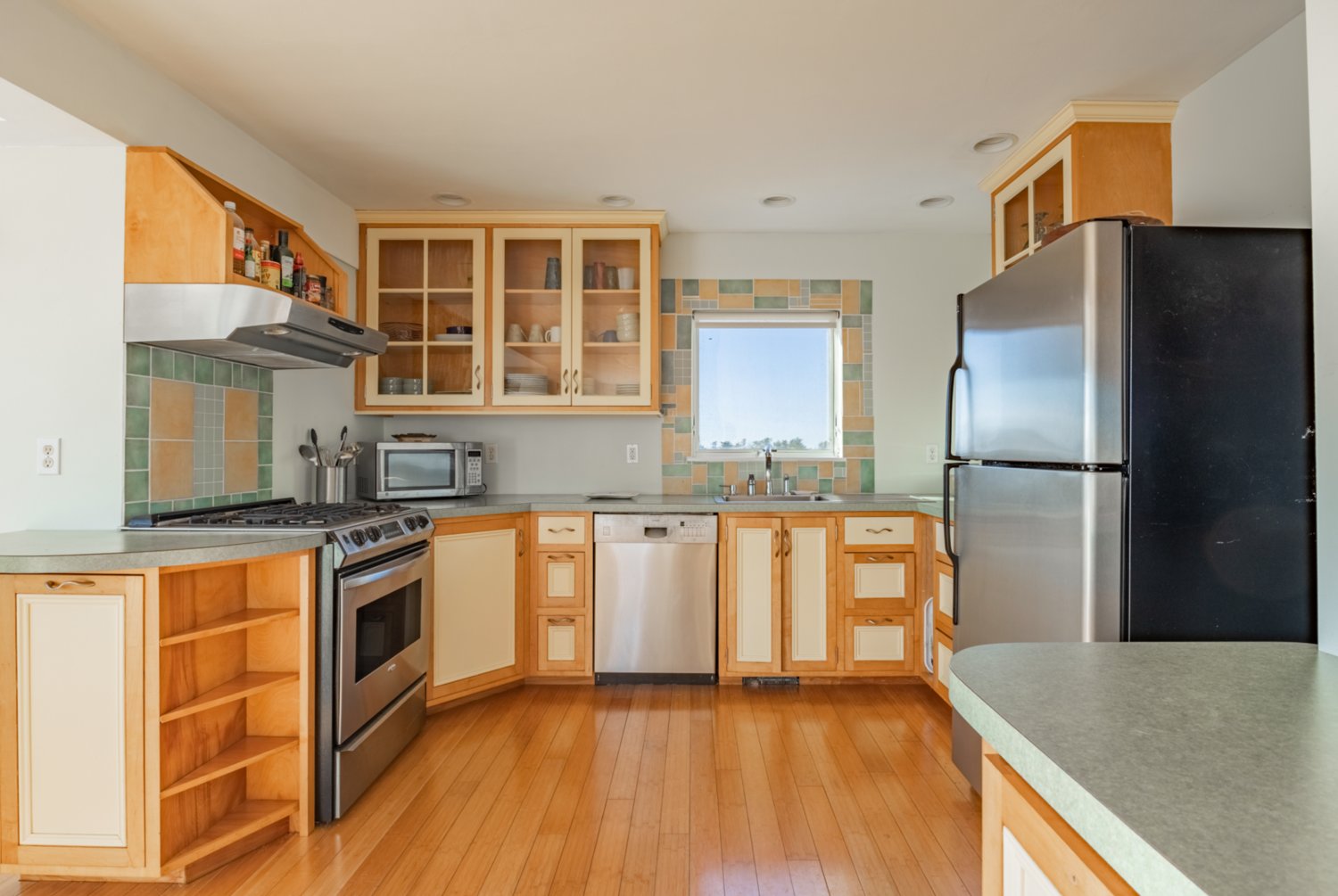 The spacious kitchen has wood floors and stainless-steel appliances by Amana, GE and Bosch.