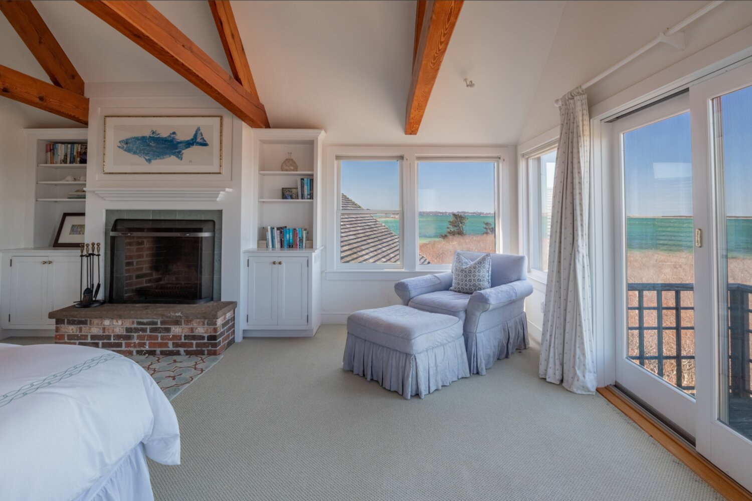 The master bedroom suite has a vaulted ceiling, a fireplace and a private deck with water views.