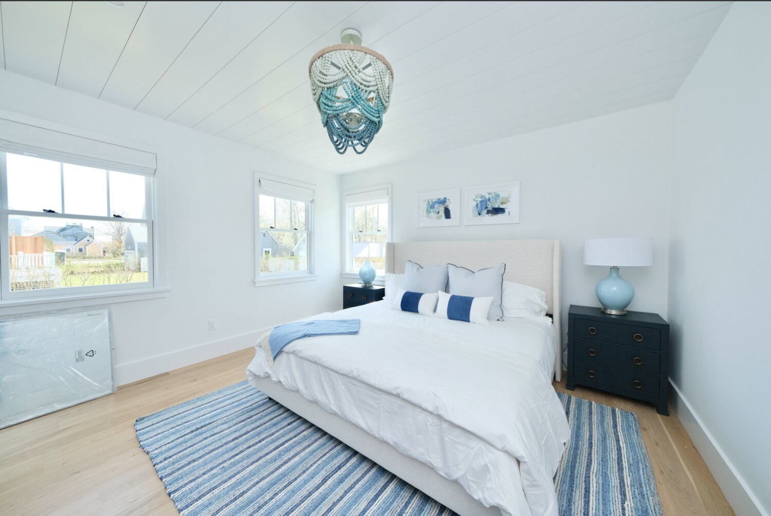 This bedroom has wood floors and multiple windows that let in plenty of natural light.