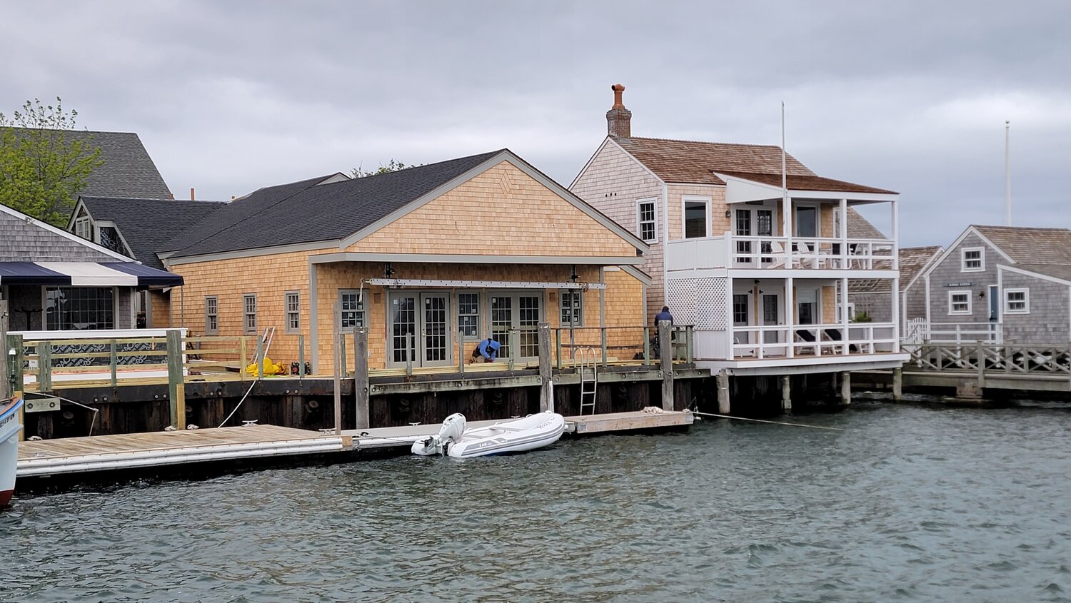 Gabriel Frasca and Kevin Burleson hope to open the Straight Wharf Fish Market restaurant in the space at left by mid-summer. The cottage of Charles Johnson, who has filed suit against the project, is at right.