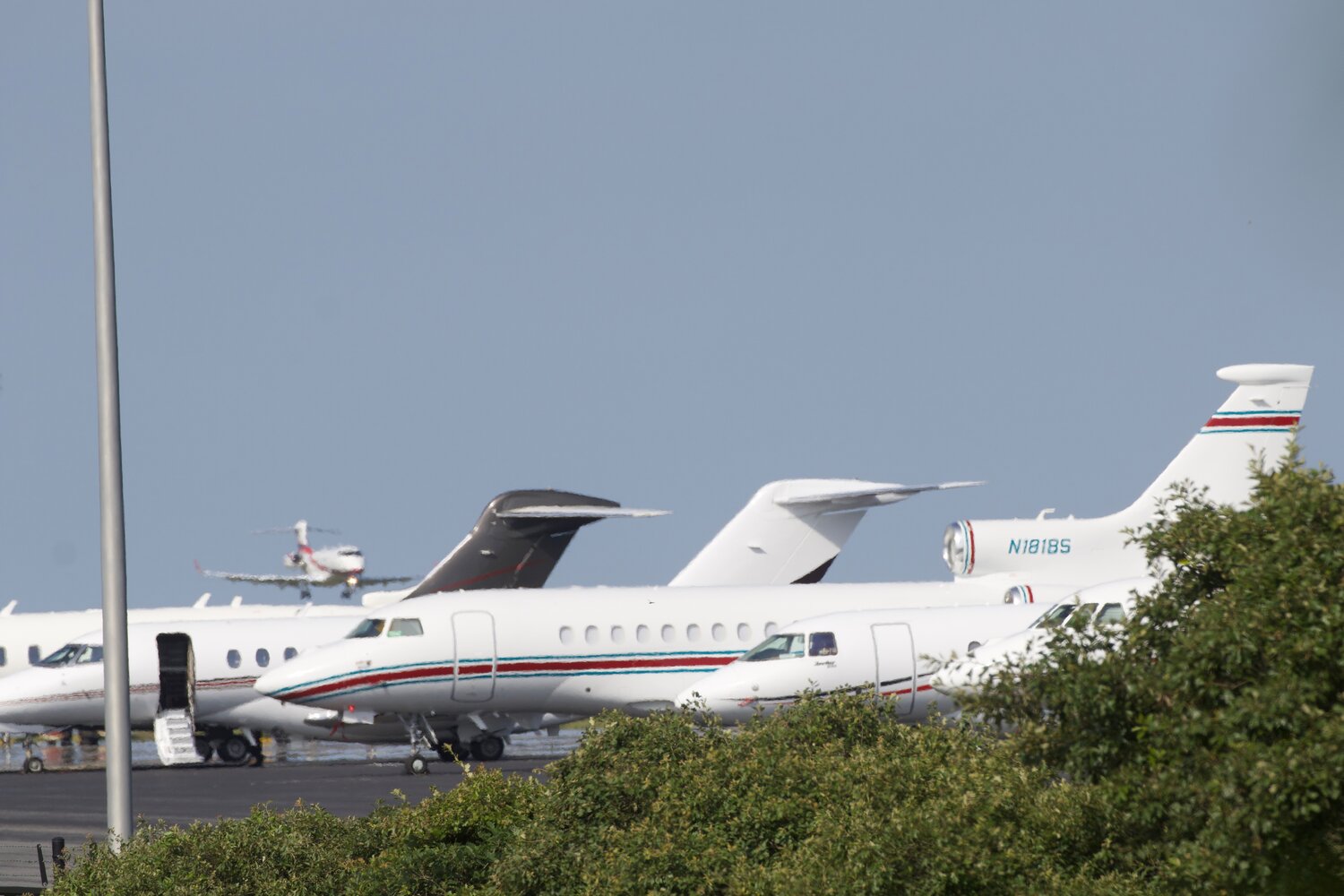 Private jets stacked up on the apron at Nantucket Memorial Airport as another approaches the runway.