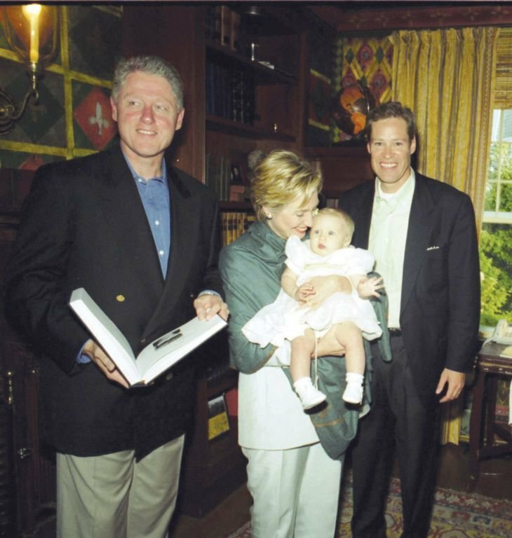 President Bill Clinton and first lady Hilary Rodham Clinton in 1999 at Bob Matthews' Cliff Road home during an American Ireland Fund event. The first lady holds Matthews' baby daughter while he looks on smiling.