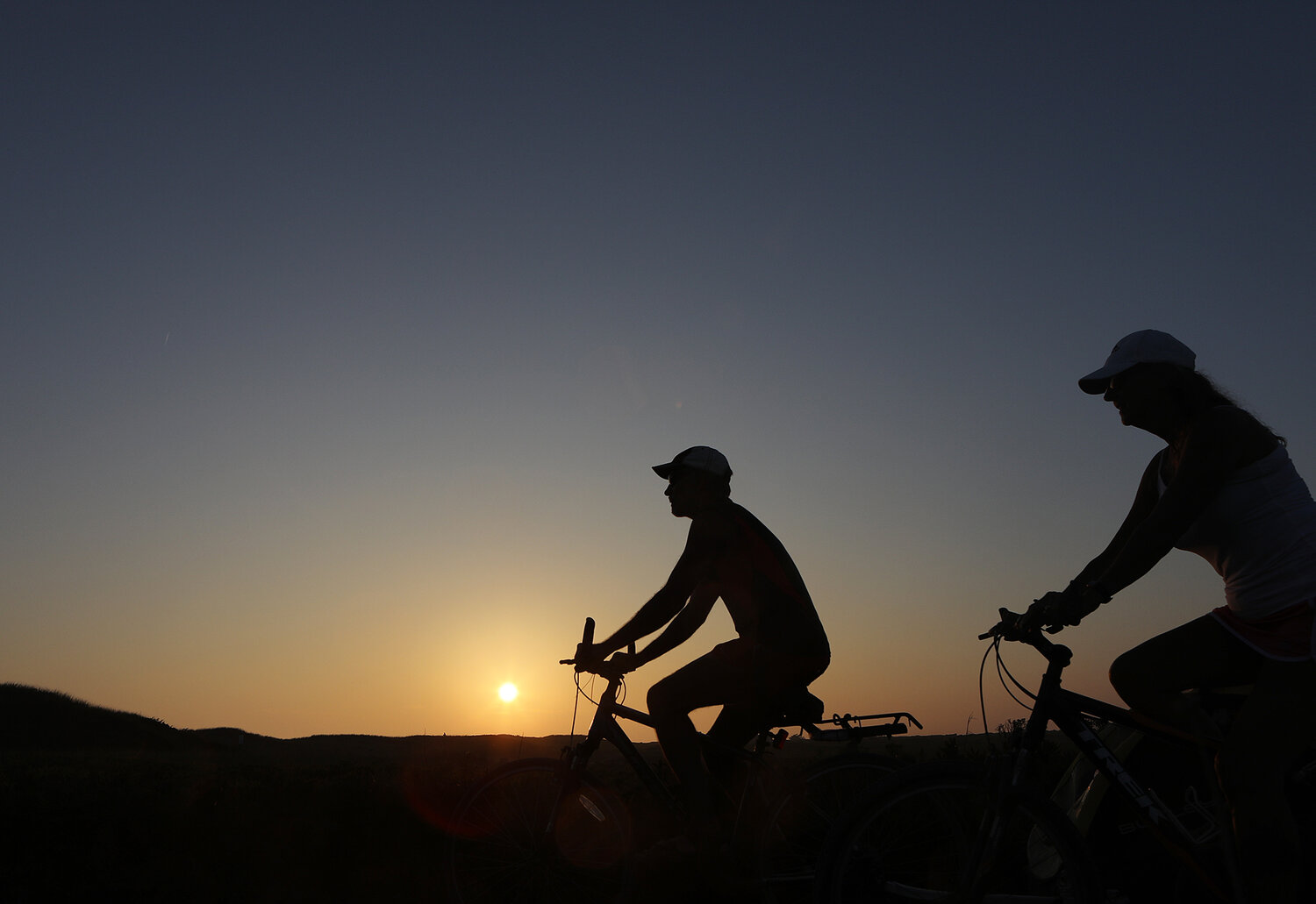 SEPTEMBER 7, 2023 -- A couple ride their bikes at sunset near Miacomet Beach on Thursday. Photo by Ray K. Saunders