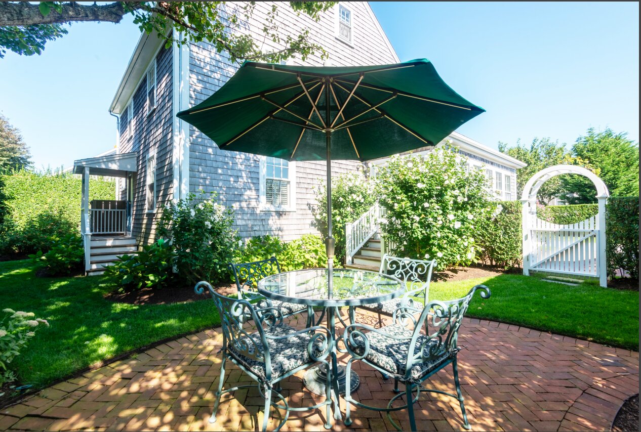 The fenced-in back yard has mature plantings surrounding a brick patio perfect for relaxing with a good book.