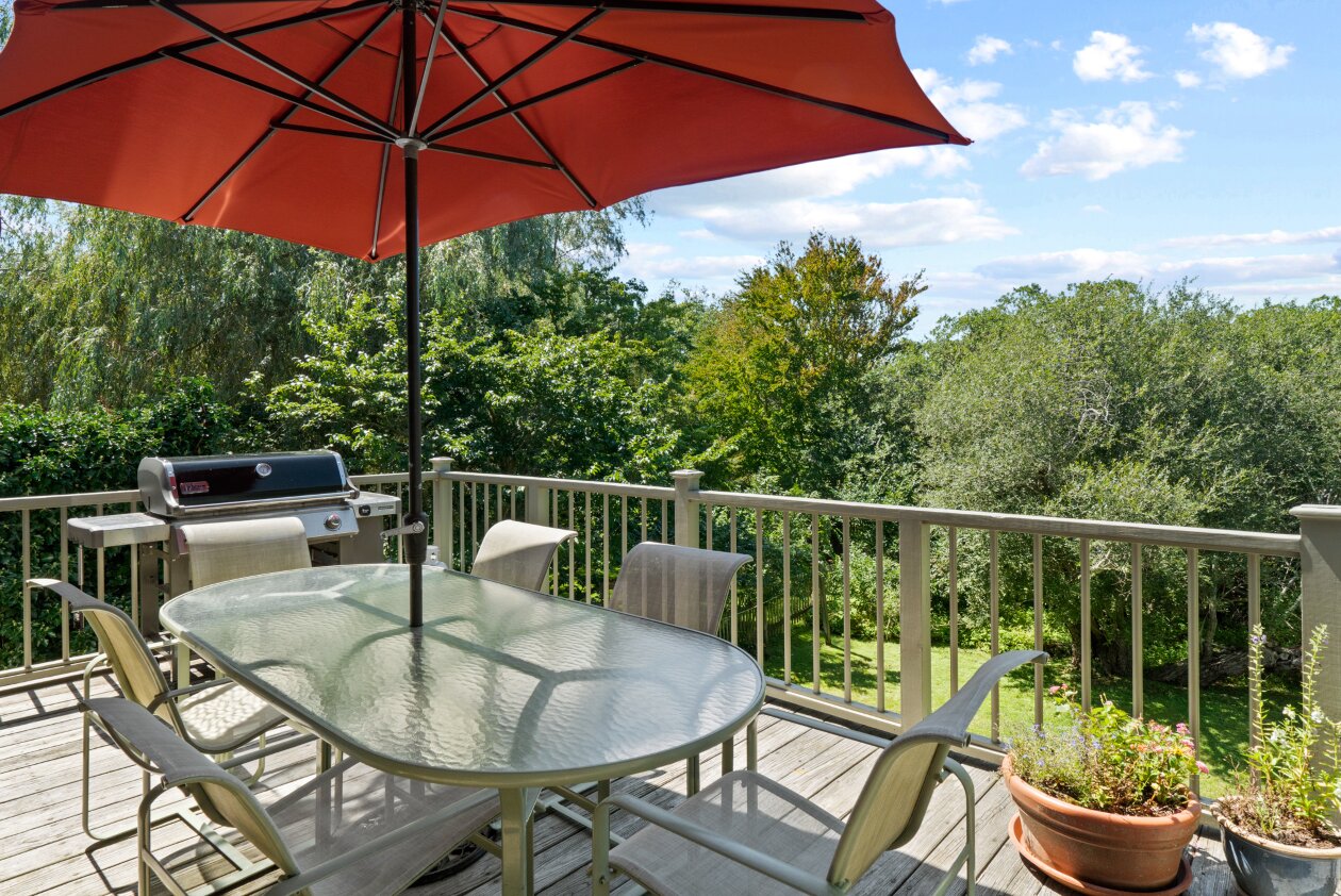 The deck off the main level of the home overlooks the back yard surrounded by mature landscaping.