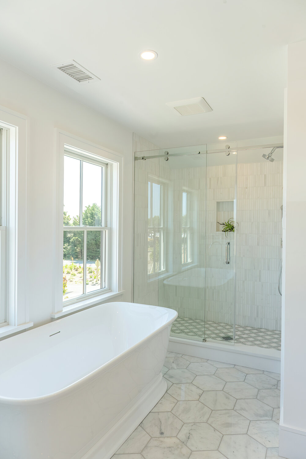 The first floor en-suite bath has a tile floor, soaking tub and glass-enclosed shower.