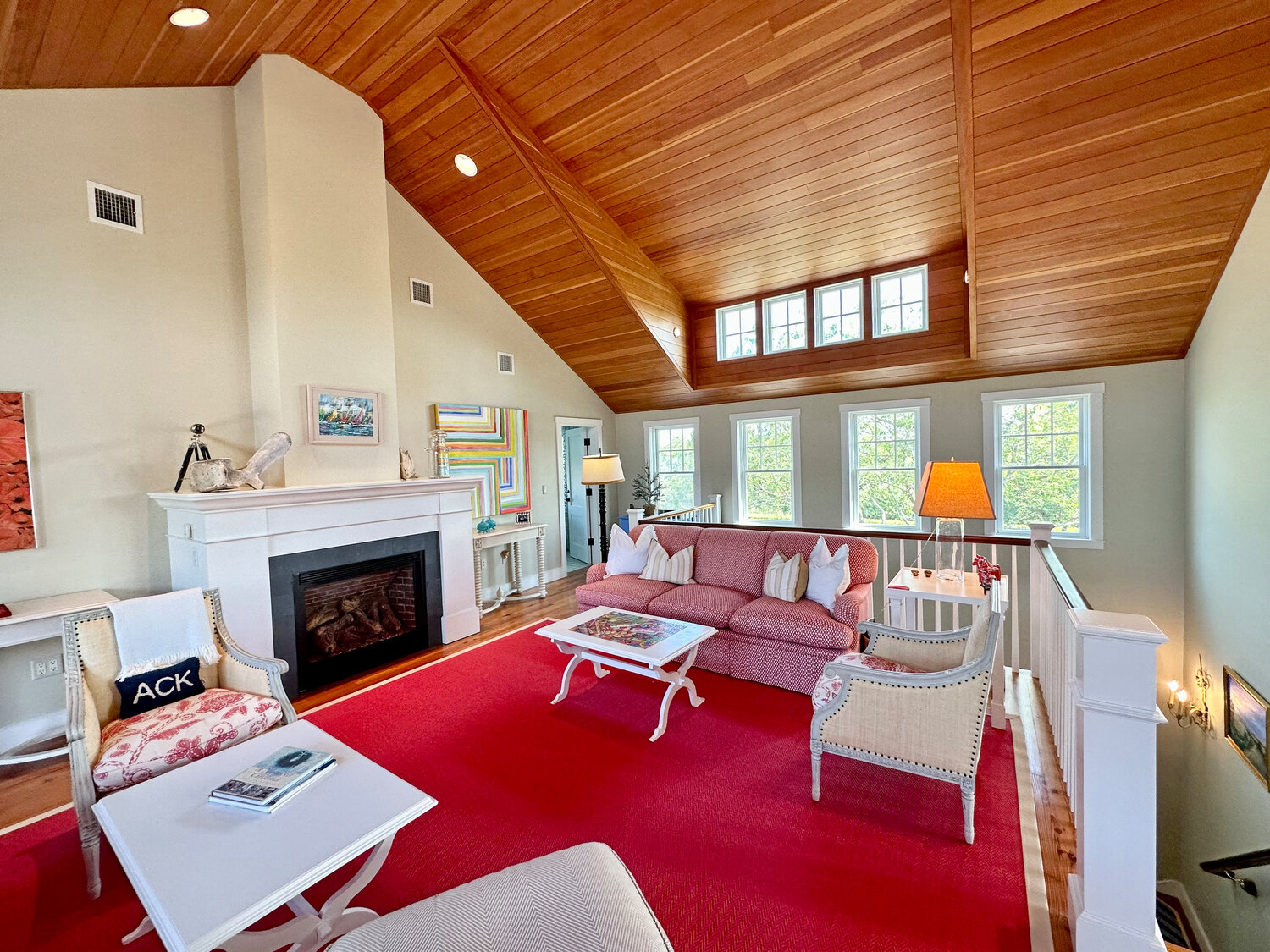 The second-floor living room has a wood-manteled fireplace and cathedral ceiling.
