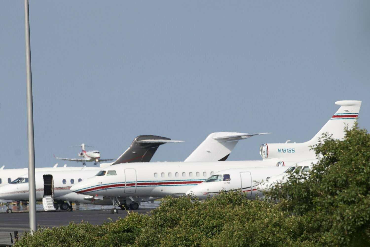 Private jets lined up on the tarmac at Nantucket Memorial Airport this summer as another approaches for landing.