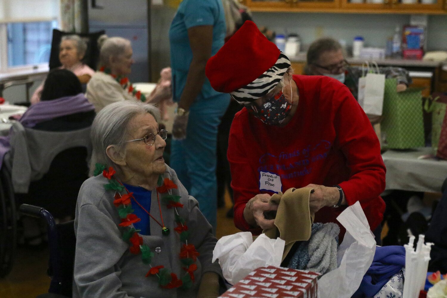 Our Island Home residents open Christmas gifts Thursday.