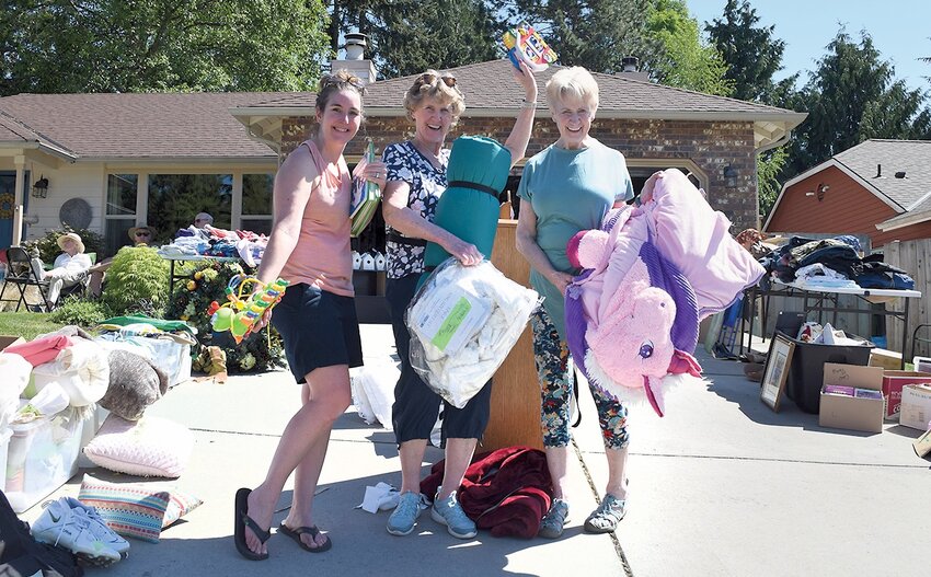Laura Conkle of Renton, Gayle Rogers of Mukilteo, and Judi Slepyan of Whidbey Island display some of their purchases from Saturday’s Great Mukilteo Garage Sale. Rogers, her daughter Laura, and sister Judi shop the sale every year.