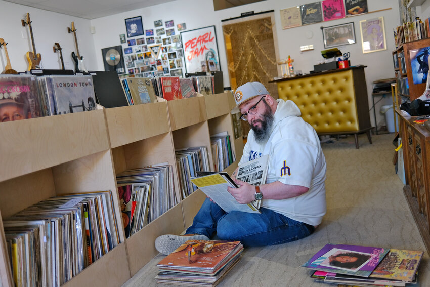 Ryan Fisher arranging vinyl LPs at Musicology Co. in preparation for this weekend’s big sale and party, which will spotlight local musicians.