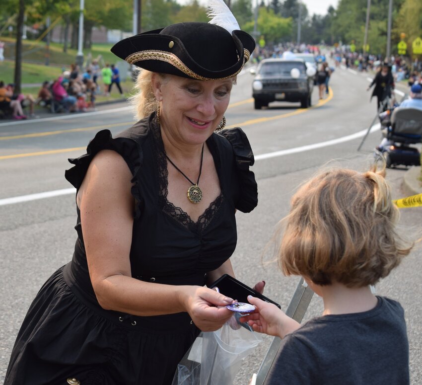 Mukilteo Mukfest Pirates of the Salish Sea’s Penny Dreadful hands out buttons to kids during the parade.