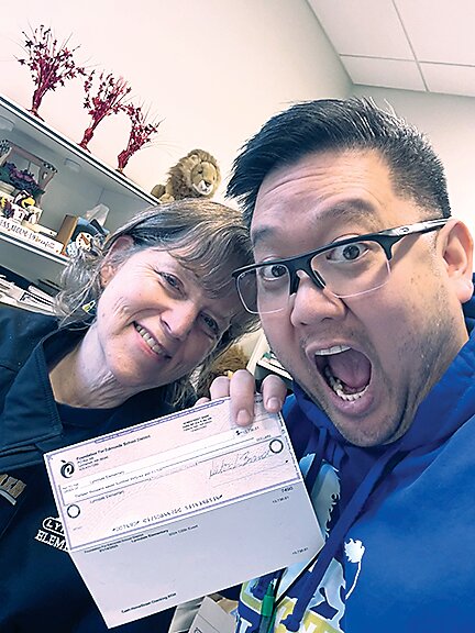 Diane Grossenbacher, Lynndale Elementary office manager, and Jimmy Vinh Xuan Nguyen, Lynndale Elementary principal, with a check received from the Foundation for Edmonds School District for nearly $14,000.  (Photo courtesy Foundation for Edmonds School District)