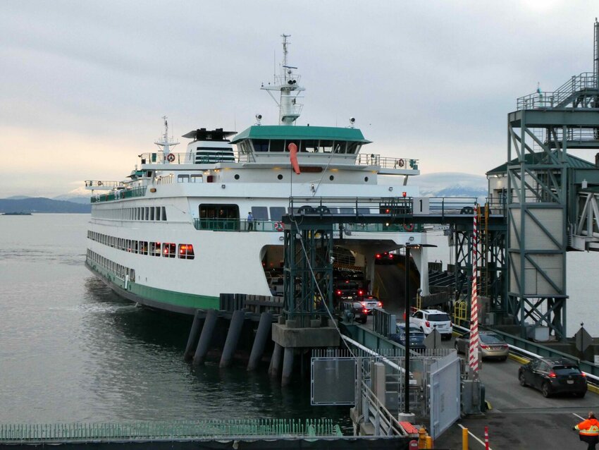 Gov. Bob Ferguson, at podium, discusses his plan to restore Washington State Ferries service during a press conference on March 6, 2025, in Seattle. To his left are Washington State Transportation Secretary Julie Meredith and state ferries chief Steve Nevey. To his right is Bremerton Mayor Greg Wheeler. (Photo by Tom Banse/Washington State Standard)