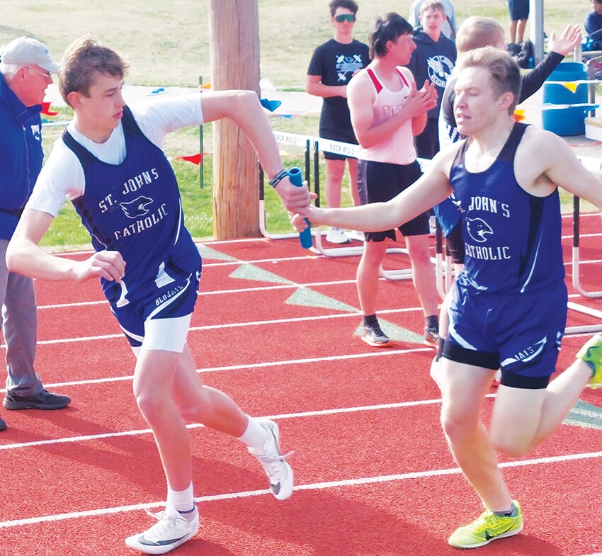 Jonas Letourneau hands off to Dominic Eilert during the 4x800m relay race for fourth place.