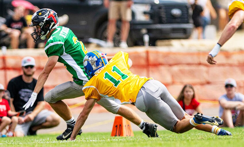 Division II (East squad Gold) player Andy Cooper #11 of Pike Valley, dives for the tackle against (West squad Green) player Hazen Rydquist #2 of Hodgeman County, during the 40th Anual 8-Man All-Star games held on June 7, in Beloit. The East team won over West, 58-0.