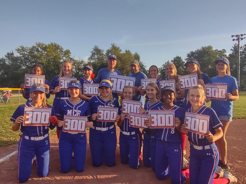The Marion C. Early softball team holds up signs to celebrate coach Mike McHolland’s 300th softball win.