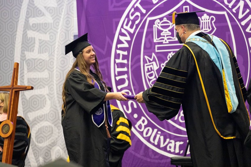 SBU graduate Allison Baker accepts her diploma from then-President Eric A. Turner at a ceremony in the Jane and Ken Meyer Wellness and Sports Center on Friday, Nov. 20.&nbsp;