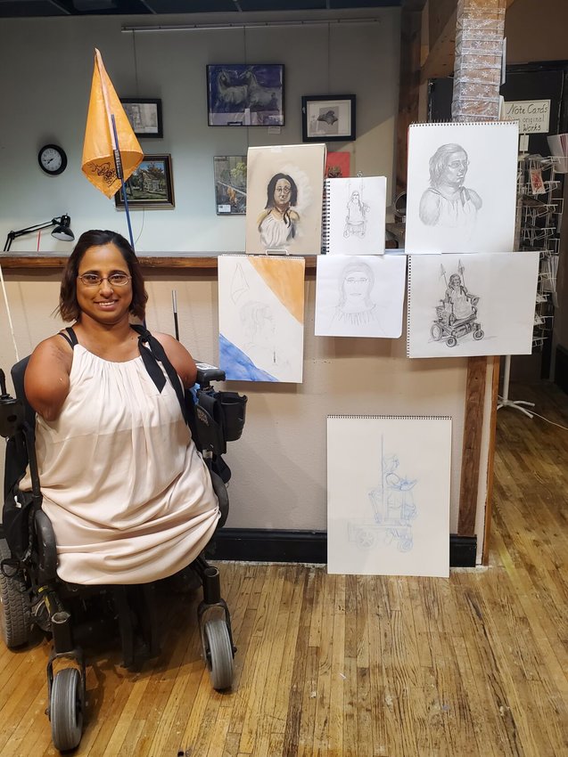 Minda Cox, model for the gallery&rsquo;s Aug. 5 live drawing session, poses for a photo alongside the event&rsquo;s results.