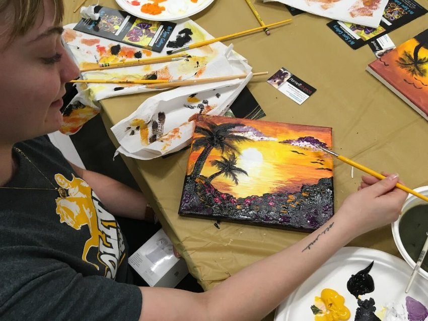 Graduate Lillee Grant adds her finishing strokes to her painting at Project Graduation. Grant plans to earn her teaching degree to become an art instructor.