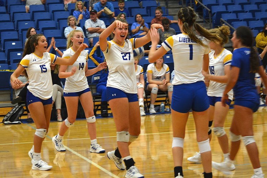 The Bolivar varsity volleyball team rushes together to cheer and congratulate one another &mdash; something they do after every play.