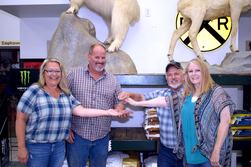 The new owners of the Whistle Stop, Rhonda and Vaughn Miller, left, are given the keys to the store by former owners, Ora and Jill Hostetler on the right.