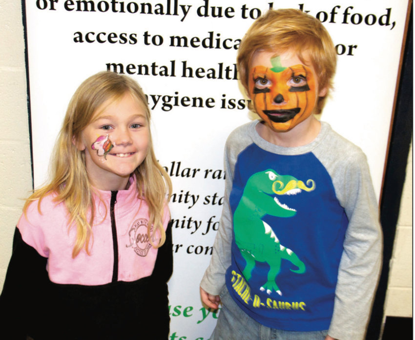 Kendra Lucee, left, and Everett Troyer pose for a photo after taking turns at the 2019 Care to Learn Fall Festival&rsquo;s face-painting station.